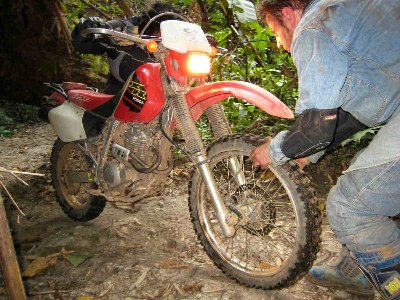 une bonne méthode pour faire avancer la moto sans forcer est de prendre la roue avant par  le pneu et le faire tourner