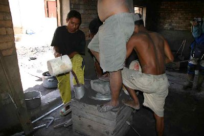 l'aluminium de récupération en fusion est versé , le démoulage s'effectue juste après, le sable noir est retamisé et sert a faire un nouveau moule à usage unique